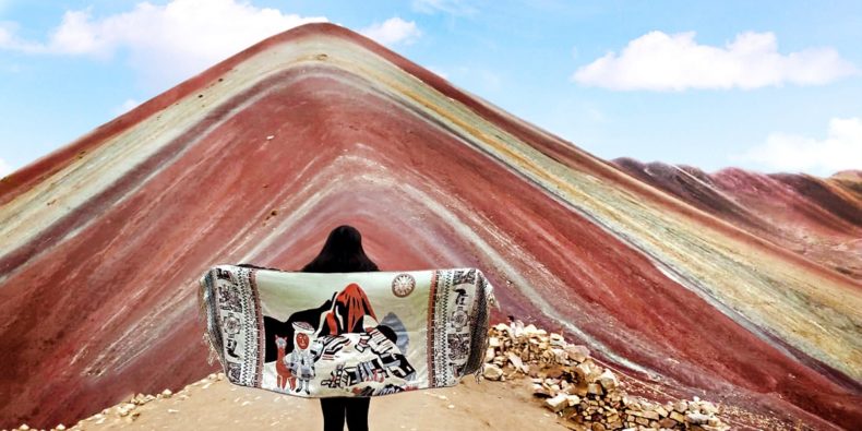 mulher com tecido peruano em frente da montanha de 7 cores - roteiro peru 8 dias