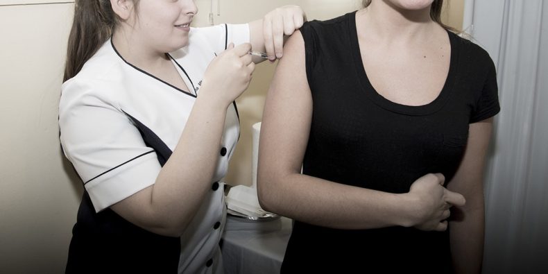 mujer aplica vacuna en brazo de otra - vacunas para viajar a perú